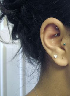 a close up of a person's ear with two piercings