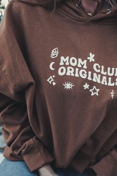 Get comfy in this classic brown colored hoodie. Mom Club Originals with doodle designs and a special puffy paint print texture. Size up if you want that oversized fit. Trendy Brown Crew Neck Hoodie, Vintage Oversized Brown Sweatshirt, Oversized Vintage Brown Sweatshirt, Brown Hoodie Sweatshirt For Spring, Brown Graphic Print Sweatshirt For Streetwear, Brown Long Sleeve Hoodie With Graphic Print, Brown Graphic Print Hoodie With Long Sleeves, Brown Crew Neck Hoodie With Letter Print, Brown Cotton Graphic Print Sweatshirt