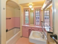 a bathroom with pink walls and flooring next to a bathtub