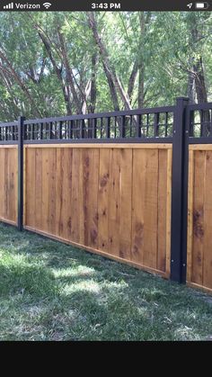 a wooden fence with black iron railings