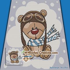 a cross stitch teddy bear with aviator's hat and goggles is shown on a blue background