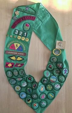 a green scarf with buttons and badges on it