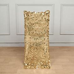 a gold sequin chair sitting on top of a hard wood floor