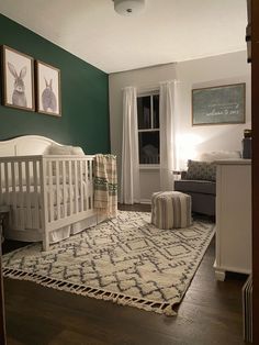 a baby's room with green walls and white furniture