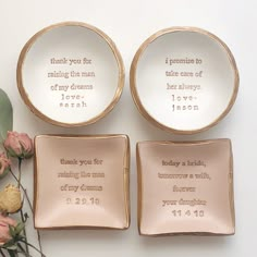 three plates with words on them sitting next to some pink flowers and greenery in front of white background