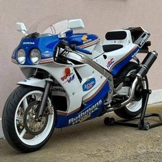 a blue and white motorcycle parked next to a building