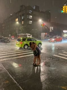 two people kissing in the rain at an intersection