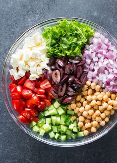 a bowl filled with chopped vegetables and chickpeas on top of a gray surface