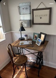 an old sewing machine sits on a table in the corner of a room with two framed pictures