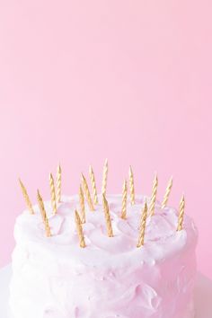 a cake with white frosting and gold sprinkles sitting on a plate