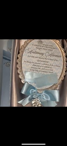 an open box with a blue ribbon on the side and a wedding card in it