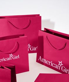 pink shopping bags with the american girl logo on them