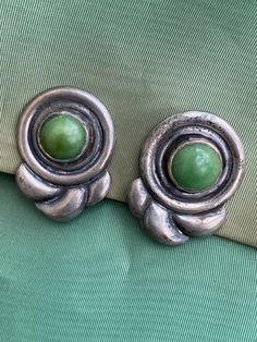 "Fabulous MCM modernist design Mexican jade, green stone Sterling silver Screw back Light - 7 grams each Nice secure clips Beautiful patina Materials: sterling silver, Mexican jade Measurements: .75 x 1.25\" (1.90 x 3.17cm) Provenance: mid1940s Stamp: Silver, Mexico Condition: Very good vintage. No issues of note. We've just given a quick wipe with jewelry cloth, leaving polishing to the next owner. See pics. Sold as is. Check measurements and/or convo with ANY questions prior to purchase as there are no returns. 20230617J3091" Green Metal Clip-on Earrings, Vintage Green Jade Earrings, Green Metal Art Deco Jewelry, Green Metal Clip-on Jewelry, Vintage Green Clip-on Jewelry, Green Clip-on Metal Jewelry, Green Clip-on Metal Earrings, Retro Green Clip-on Earrings, Vintage Green Sterling Silver Earrings