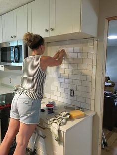 a woman standing on top of a kitchen counter