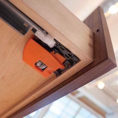 an orange piece of tape is sticking out of the door handle on a wooden cabinet