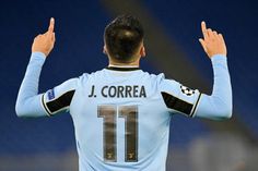 a soccer player is holding his hands up in the air while wearing a light blue uniform