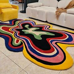 a living room filled with white couches and colorful rugs on the floor next to two yellow chairs