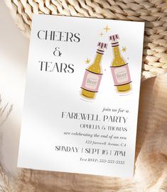 cheers and tears party card with two champagne bottles on the front, next to a wicker basket