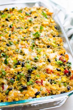 a casserole dish with vegetables and cheese in it on a white tablecloth