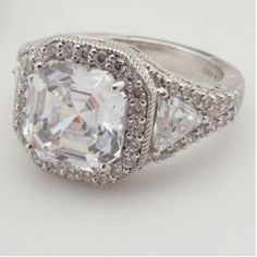 an engagement ring with three stones on the side and two diamonds in the middle, all around it