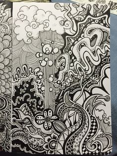 some black and white doodles are on top of a book with an ink pen