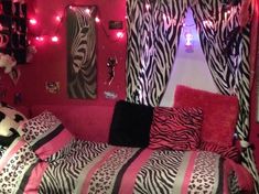 a zebra print bed in a pink room with black and white accessories on the walls