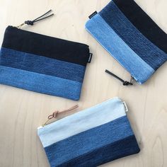 three blue and black striped pouches sitting on top of a wooden table