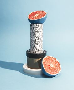 two pieces of grapefruit sitting next to each other on top of a blue surface