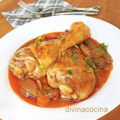 a white plate topped with pasta and meat covered in sauce on top of a wooden table