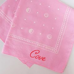 two pink napkins with the word love printed on them, sitting next to each other