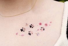 a woman's chest with small flowers and hearts tattooed on the back of her chest