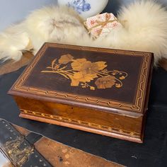 an old wooden box sitting on top of a table next to a vase and other items