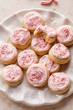 a white plate topped with cookies covered in pink frosting