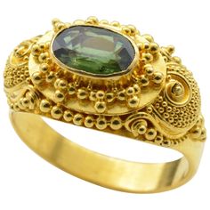 Intricate detail and spirals swirl around this deep green faceted tourmaline ring. Set in high carat 22K yellow gold this ring makes a statement fit for the Maharaja. Royal, regal and bright, the yellow gold glows in classical Indian fashion with the illuminating grassy green tourmaline ( aprox 1.0 ct). The wind-up piano box plays music and the lid to the keys lifts up uncovering the tiny golden keyboard. The ring size is 6.75 and can be sized to fit your finger. Kemp Ring, Luxury Oval Tourmaline Emerald Ring, Formal Tourmaline Rings For May Birthstone, Gold Ring Images, Thick Gold Ring, Haute Jewelry, Indian Rings, Jewelry Piercing, Contemporary Jewelry Design