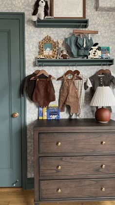 a dresser with two baby clothes on top of it