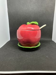 a red apple sitting on top of a green plate