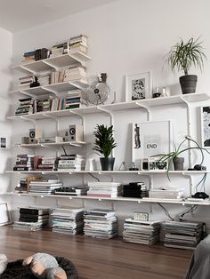 a living room filled with lots of books and furniture