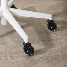 a white and black dolly sitting on top of a carpeted floor next to a wall