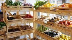 several wooden crates filled with different types of fruits and vegetables