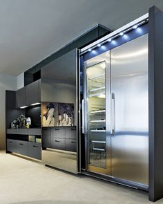 a modern kitchen with stainless steel refrigerators and built - in cabinets, including an oven