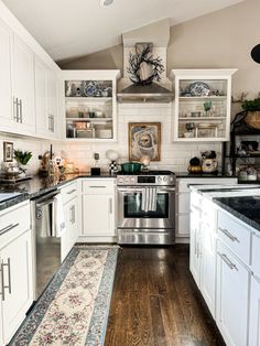 a kitchen with white cabinets and wood floors