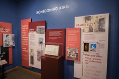 some posters and pictures are on display in a room with blue walls, black and white photos