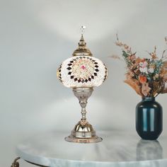 a table with two vases on it and a lamp in the middle next to it