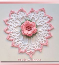 a crocheted doily with a pink flower on it that says be my valentine