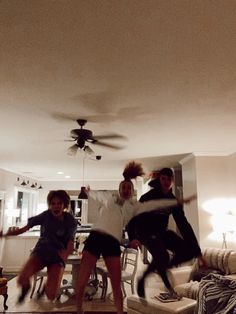 three people are dancing in the living room