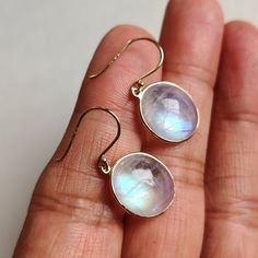 ITEM DESCRIPTION: >> The earrings are made from Solid 14K Yellow Gold. Gemstone used is absolutely natural and ethically sourced. >> Natural Rainbow Moonstone in oval shape and cabachon cut with bezel setting is studded on it with utmost precision.  >> This is a minimalist design and is absolutely hassle-free and everyday jewelry.  Gem: Rainbow Moonstone Gem size: 12.5x14.5 mm  Gem weight: 14.32 carats Gold purity: 14K (58.33% approx.) Gold weight: 0.80 grams  Gross weight: 3.66 grams The Gold purity is guaranteed and it comes with authentic 14K gold hallmark. Since these Earrings are handmade, they are Nickel/Lead FREE.  CUSTOMIZATION: --> You can choose your own gemstone. --> Kindly drop a message for more options. CUSTOMER SUPPORT: We are available 24/7 to respond to all your queries! White Bezel Setting Earrings For Gift, Formal Round Moonstone Earrings, Oval Moonstone Earrings For Gift, Elegant Moonstone Birthstone Earrings, Moonstone Round Yellow Gold Earrings, Round Moonstone Yellow Gold Earrings, Yellow Gold Round Moonstone Earrings, Moonstone Yellow Gold Round Earrings, Round Moonstone Cabochon Earrings