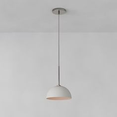 a white light hanging from the ceiling in a room with gray walls and flooring