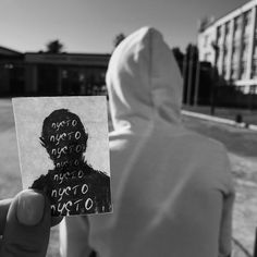 a person holding up a piece of paper with the image of a man's face on it