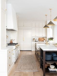 a kitchen with white cabinets and blue plates on the counter top, along with an area rug