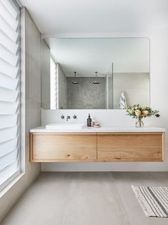 a bathroom with a large mirror and wooden vanity